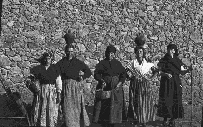 Fotografía de mujeres portando agua en la finca Dehesa de Cuaternos de Cuacos de Yuste que forman parte de la exposición que se puede ver en la Sala Pintores 10 de Cáceres