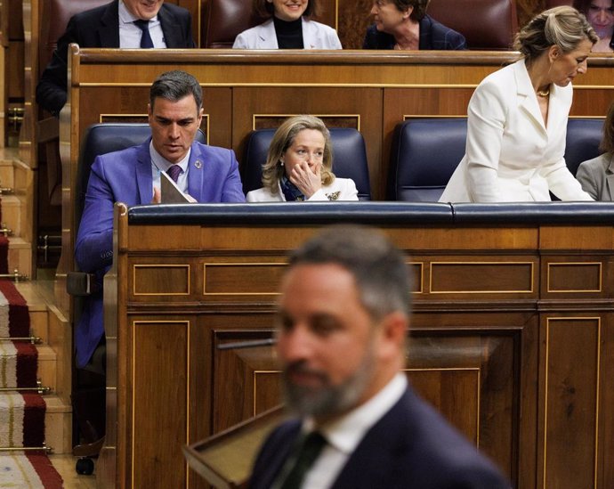 El presidente del Gobierno, Pedro Sánchez, mientras pasa el líder de VOX, durante un debate de la moción de censura.