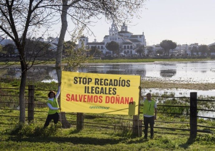 Activistas colocan la pancarta.