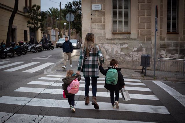 Archivo - Dos niñas de la mano con una mujer a su llegada al primer día de clase en Barcelona, Cataluña, (España).