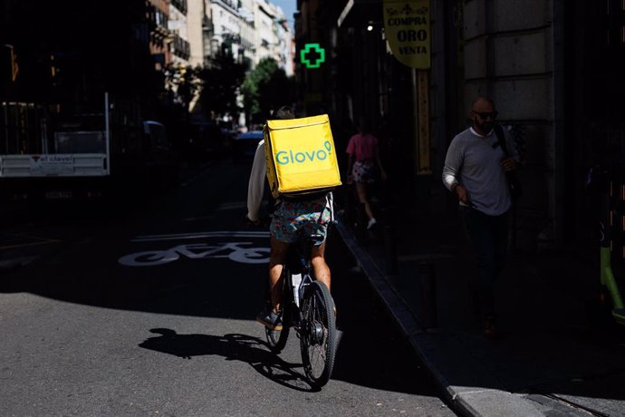 Archivo - Un repartidor de Glovo en bicicleta por una calle del centro de Madrid, en una imagen de archivo.