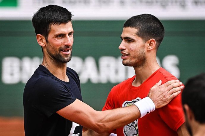 Archivo - Novak Djokovic saluda a Carlos Alcaraz tras un entrenamiento en Roland Garros 2022