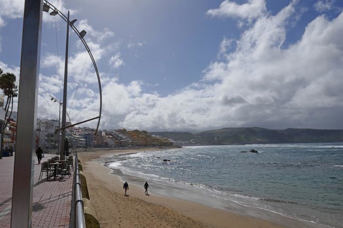 Archivo - Dos personas pasean por la playa en Las Palmas de Gran Canaria, en Canarias (España), a 4 de febrero de 2021. 