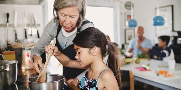 Mujer cocinando en casa con su hija