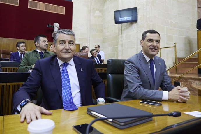 El presidente de la Junta de Andalucía, Juanma Moreno, (d) junto al consejero de Presidencia, Interior y Diálogo Social de la Junta de Andalucía, Antonio Sanz, (i) durante la primera jornada del Pleno del Parlamento andaluz en el Parlamento de Andalucía
