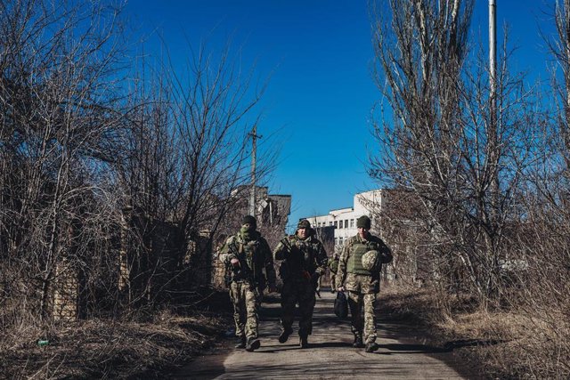 Archivo - Varios soldados ucranianos caminan frente a unas ruinas en un pueblo cercano a la línea de contacto, a 15 de febrero de 2022, en Marinka, Oblast de Donetsk (Ucrania).