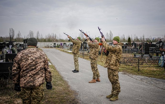 25 February 2023, Ukraine, Butscha: Comrades shoot salute for the fallen soldier Ihor Dyukarev, who was killed by a tank shell in the east, during his funeral service at the Butsha cemetery. Photo: Kay Nietfeld/dpa