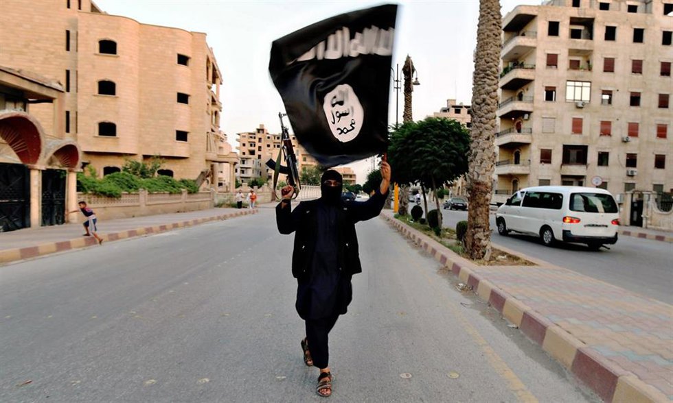 Miembro de Estado Islámico con una bandera durante un desfile militar en la ciudad siria de Raqqa en 2014