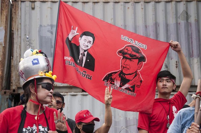 Archivo - Manifestantes con una pancarta con las caras del ex primer ministro Thaksin Shinawatra y el general Jattiya Sawasdipol.