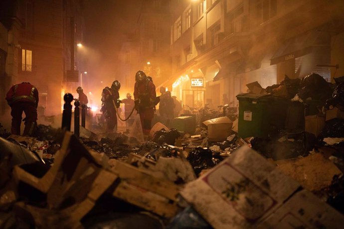23 March 2023, France, Paris: Firefighters check garbage after extinguishing a fire during a demonstration against pensions reforms. Photo: Anna Kurth/AFP/dpa