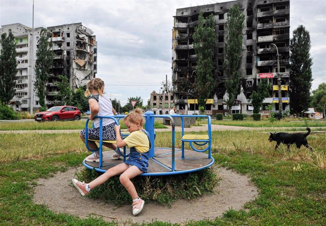 Archivo - Niños ucranianos jugando en parque de Borodianka frente a edificios destruídos por bombardeos rusos