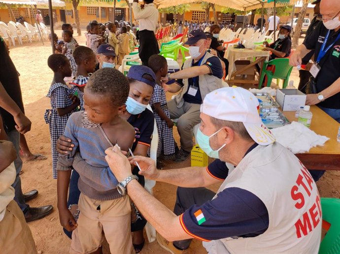Un cooperante vacunar a un niños contra la meningitis en Costa de Márfil.