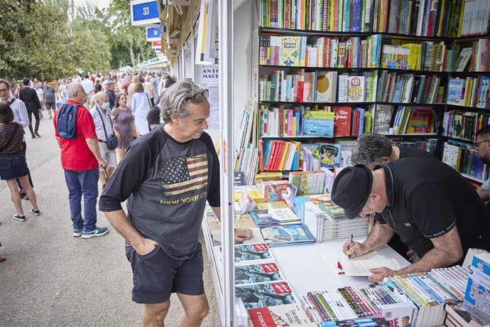 Archivo - El fotógrafo de Europa Press Ricardo Rubio (2i) y el periodista Germán Pose (1d) en la firma de la fotonovela 'Mondo Difficile', en la Caseta 32 de la Feria del Libro, a 2 de junio de 2022, en Madrid (España). 