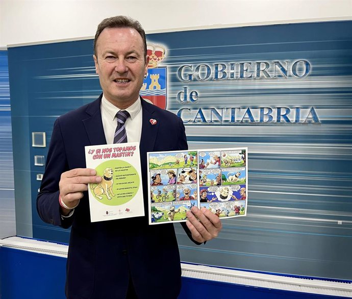 El consejero de Ganadería, Guillermo Blanco, con el folleto editado por el Gobierno sobre la labor ganadera de los perros mastines