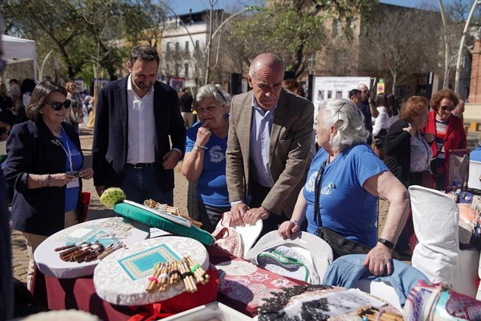 Muñoz visita el trabajo artesano de medio millar de encajeras de bolillos en un encuentro nacional que acoge la Alameda de Hércules.