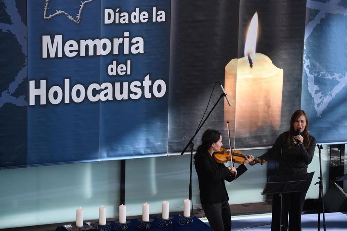 Archivo - Una mujer toca el violín mientras otra canta durante una ceremonia para conmemorar el Holocausto, en la Asamblea de Madrid, a 31 de enero de 2023, en Madrid (España). 