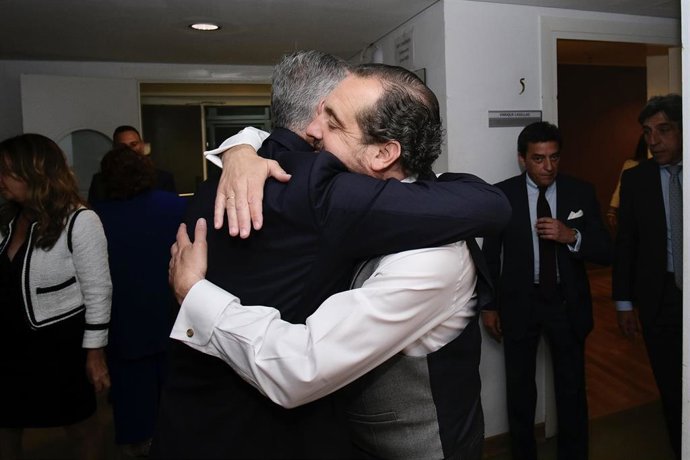 El candidato del PP a la Alcaldía de Sevilla, José Luis Sanz, se abraza con el pregonero de la Semana Santa de 2023, Enrique Casellas.