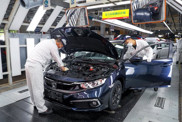 Archivo - 23 March 2020, China, Wuhan: Two men work in a car factory on a Honda vehicle. For the first time since the outbreak of the novel coronavirus (COVID-19), China last week for the first time reported no new local infections nationwide. Photo: -/TP