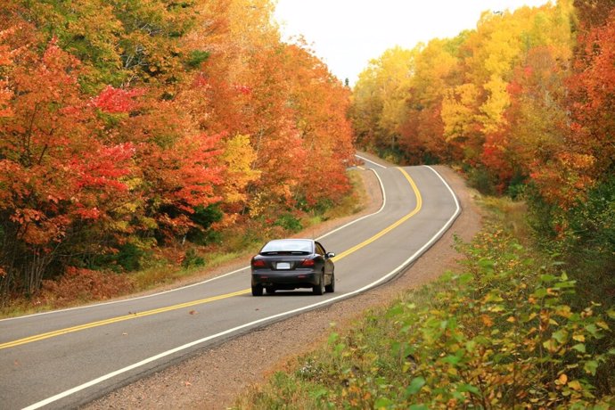 Archivo - Un coche circula por una carretera en Otoño