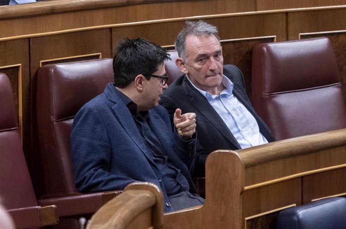 El secretario primero del Congreso y diputado de ECP, Gerardo Pisarello (i), y el secretario general del PCE y diputado de Unidas Podemos en el Congreso, Enrique Santiago (d), conversan  durante una sesión plenaria en el Congreso de los Diputados, a 9 d