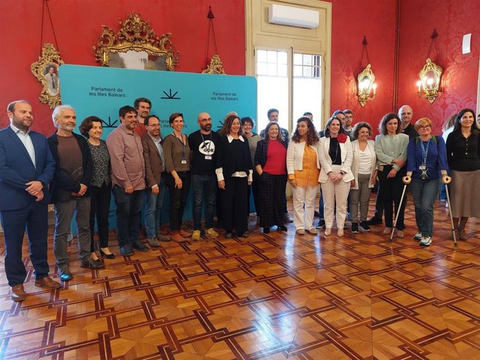 Miembros de las entidades impulsoras de la ILP con responsables del Govern y representantes de los partidos que la han apoyado