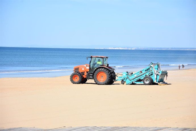 Una máquina limpia una zona de la playa de Punta Umbría (Huelva).