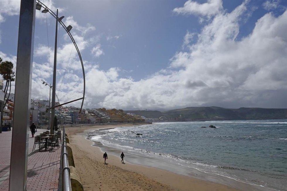 Archivo - Dos personas pasean por la playa en Las Palmas de Gran Canaria, en Canarias (España), a 4 de febrero de 2021. Canarias recibió este miércoles una profunda vaguada atlántica que provocará un aumento considerable de la inestabilidad atmosférica 