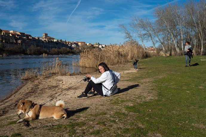 Una mujer junto a su perro.