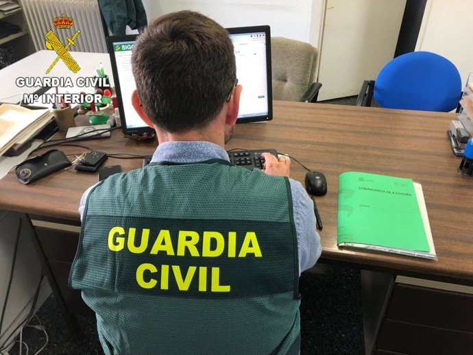 Archivo - Guardia Civil en un ordenador. Archivo.