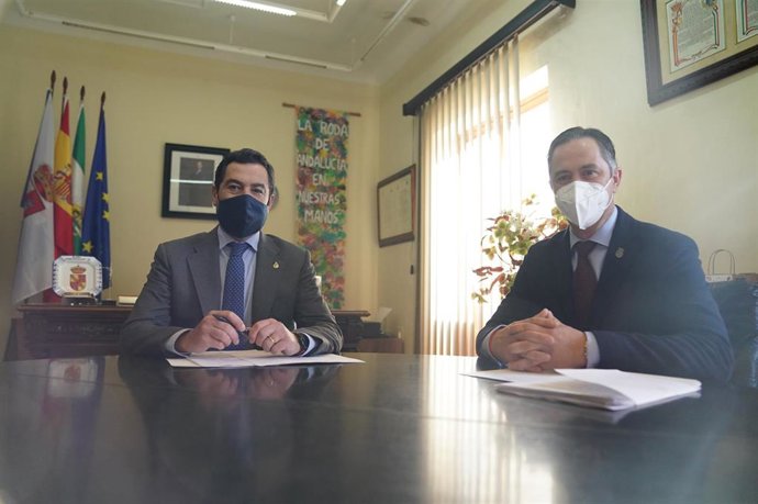 Archivo - El presidente de la Junta de Andalucía, Juanma Moreno (1i),  con el alcalde de La Roda de Andalucía, Juan Jiménez (1d), durante su visita institucional al municipio sevillano en 2021.