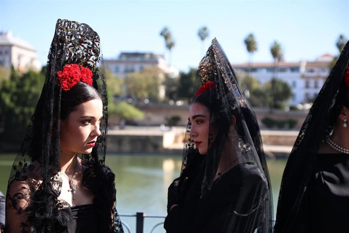 Dos mujeres vestidas de mantilla con motivo de la presentación de un evento de promoción de los diseñadores, celebrado en la calle Betis.