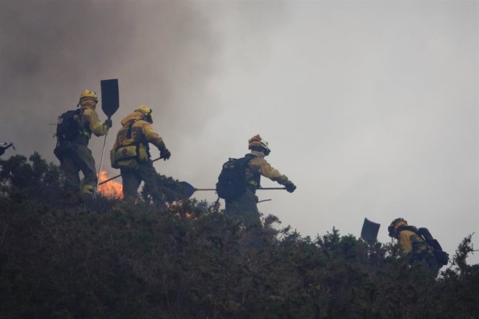 Bomberos de Asturias trabajan para extinguir las llamas en un incendio forestal, a 28 de marzo de 2023, en Toraño, Parres, Asturias (España). 