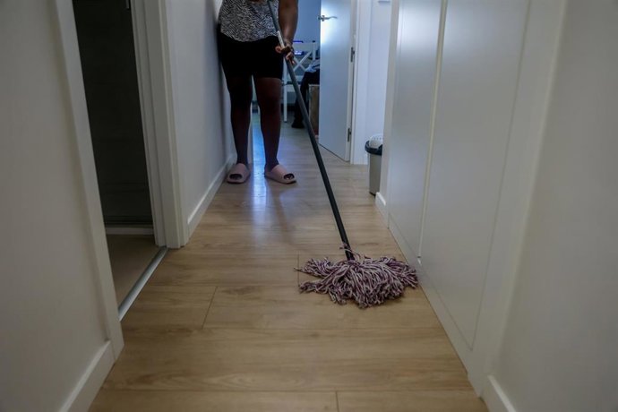 Archivo - Una empleada de hogar limpia con una fregona.