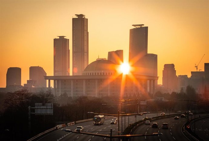 Archivo - Amanecer en el distrito financiero de Yeouido, Seúl (Corea del Sur), con el edificio de la Asamblea Nacional en primer plano.