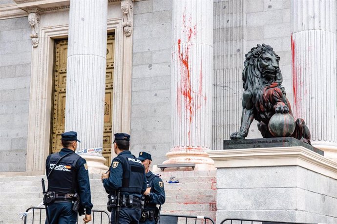 Tres agentes de Policía Nacional delante de las escalinatas del Congreso de los Diputados que han sido teñidas con pintura roja por activistas de Futuro Vegetal y Rebelión Científica, a 30 de marzo de 2023, en Madrid (España). 