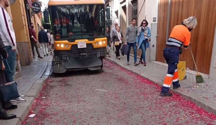 Operario de Lipasam trabajando tras el paso de una hermandad de Sevilla en Semana Santa.