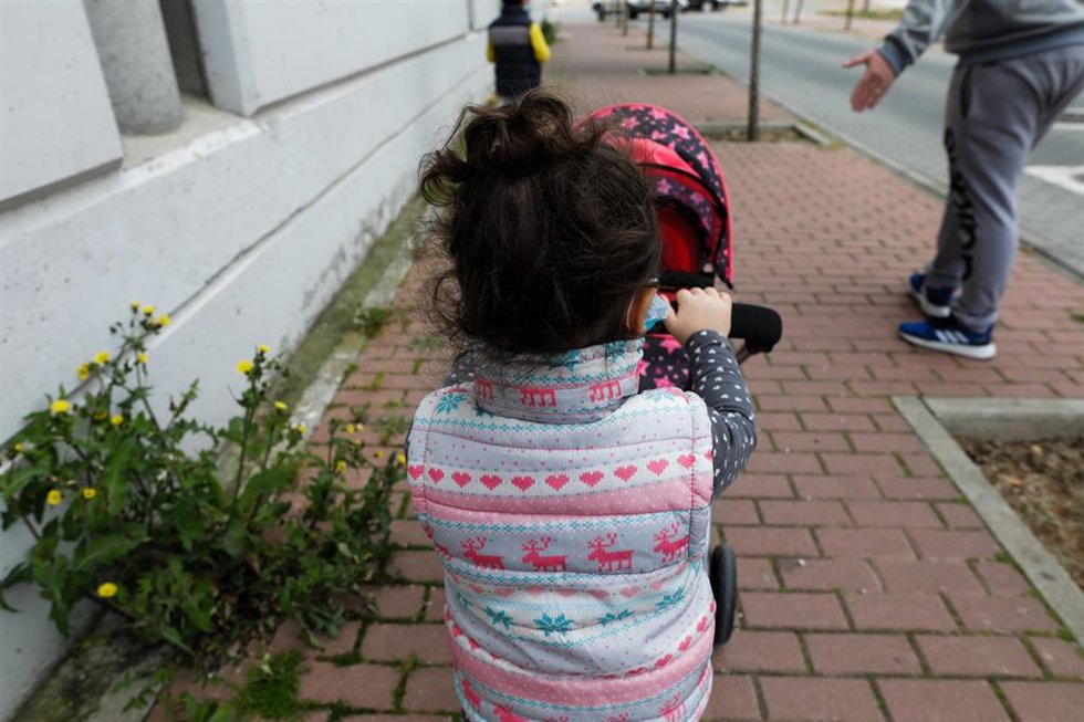 Archivo - Una niña pasea por la calle empujando un carrito con un bebé de juguete
