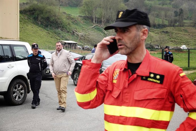 El presidente del Gobierno de Asturias, Adrián Barbón (c) y un bombero de la Unidad Militar de Emergencias (UME), que trabaja en las labores de extinción del incendio, en el puesto de mando avanzado de Navelgas, a 30 de marzo de 2023, en Navelgas, Tineo