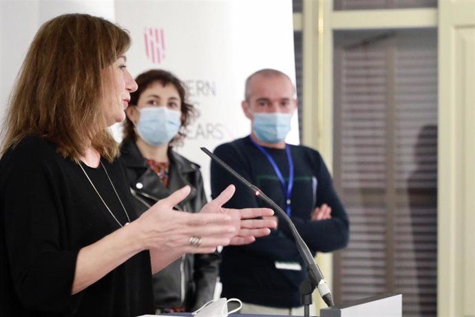 Archivo - La presidenta del Govern, Francina Armengol, interviniendo en un acto público con Oriol Lafau al fondo, en marzo de 2022.