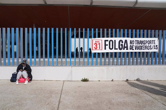 Una mujer al lado de un cartel de la huelga de transporte, tras una concentración por la huelga del transporte de viajeros, en la estación de autobuses de Santiago, a 31 de marzo de 2023, en Santiago de Compostela, A Coruña, Galicia (España). La huelga,