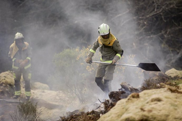 Dos brigadistas forestales trabajan para extinguir las llamas en un incendio forestal, a 30 de marzo de 2023, en Baleira, Lugo, Galicia (España). El incendio forestal declarado en Baleira (Lugo) continúa activo y afecta ya a 1.100 hectáreas, según recog