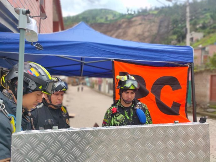 Personal de  la Unidad de Rescate y Emergencias Médicas de Ecuador realizando trabajos de búsqueda y rescate en Alausí tras un corrimiento de tierra