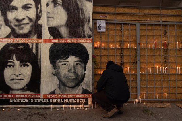Archivo -  Un hombre enciende una vela junto al Estadio Nacional de Chile durante una conmemoración del 48 aniversario del golpe de Estado en Chile, que dio paso a la dictadura de Pinochet.