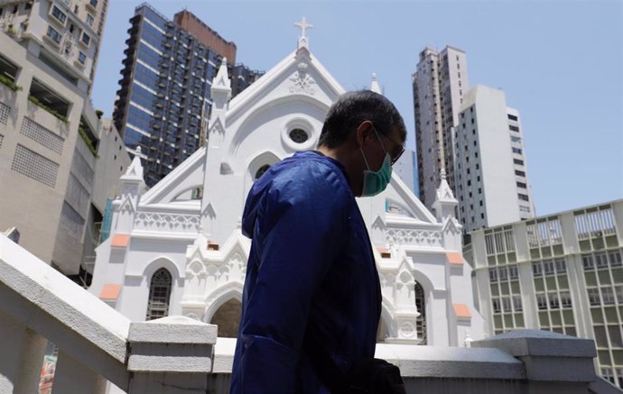 Archivo - Un hombre con mascarilla pasea junto a la Iglesia de la Inmaculada Concepción en la ciudad china de Hong kong