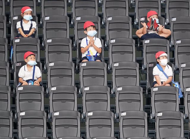 Archivo - Niños japoneses sentados en las gradas durante un partido de baloncesto  