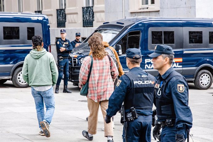 Varios activistas que han grabado la acción junto a agentes de Policía Nacional después de que activistas de Futuro Vegetal y Rebelión Científica hayan teñido de rojo las escalinatas del Congreso de los Diputados, a 30 de marzo de 2023, en Madrid (Españ