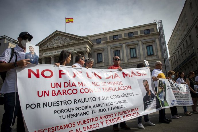 Archivo - Familiares de marineros fallecidos sostienen pancartas y fotografías en una concentración a las puertas del Congreso. 