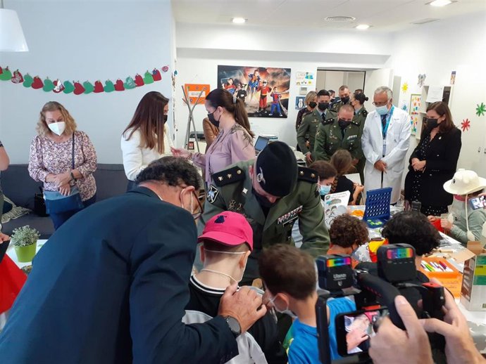 Los menores ingresados en el Hospital Materno Infantil reciben la visita de la Brigada Paracaidista y las Reales Cofradías Fusionadas