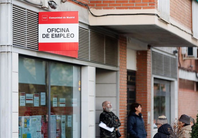 Varias personas esperan en la entrada de una oficina del SEPE, a 4 de abril de 2023, en Madrid (España). 