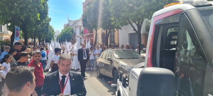 La grúa retira un coche que obstaculiza el recorrido de una hermandad de Semana Santa